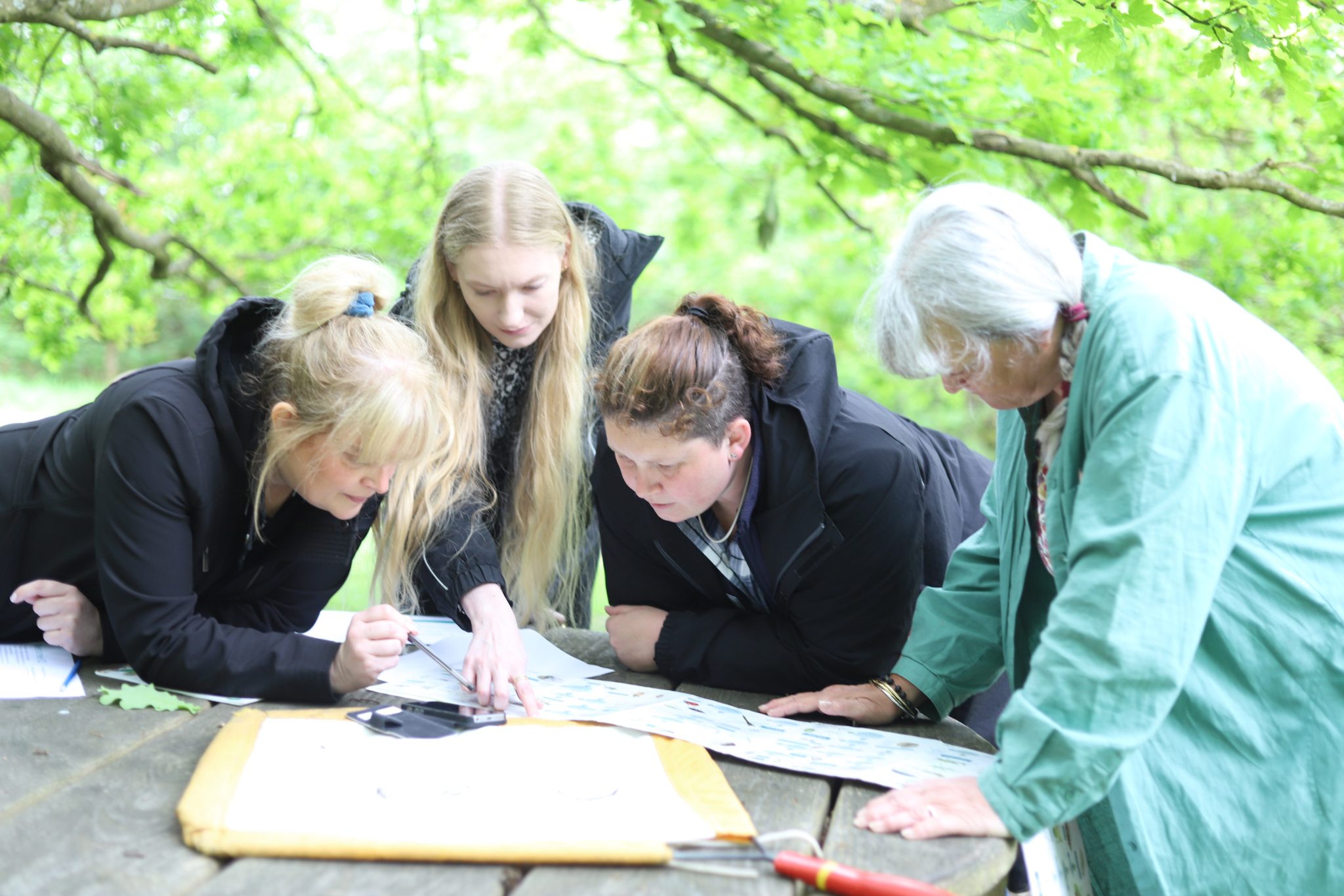Three members of the Fortis Trust Outreach Team. All three women are looking at the camera and are smiling. In the background is a school hall.